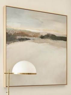 a painting hanging on the wall above a lamp