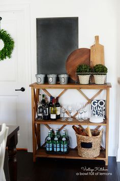 a shelf with bottles and other items on it in a dining room next to a door