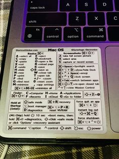 a laptop computer sitting on top of a checkered tablecloth covered desk area with keyboard and mouse stickers