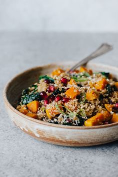 a bowl filled with rice and veggies on top of a gray countertop