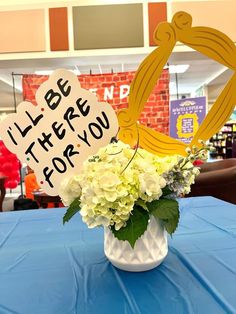 a vase filled with white flowers sitting on top of a blue table