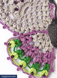 two crocheted doilies with green and purple trims, one has a flower on it