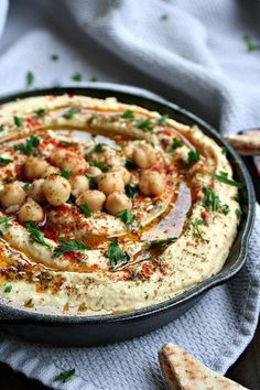 hummus in a skillet with garnishes and parsley on top