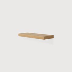 a wooden shelf sitting on top of a white wall