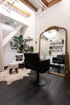 a chair and mirror in a room with wooden floors, white walls and exposed ceilings