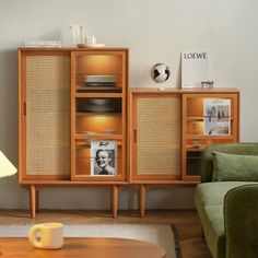 a living room with a green couch and wooden cabinet