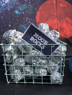 a basket filled with silver foil sitting on top of a table next to a red moon