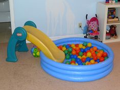 a child's play area with balls and a slide in the center, including toys