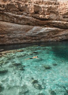 a person swimming in the clear blue water