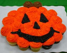 an orange cupcake with a jack - o'- lantern face on it