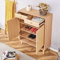 a small wooden cabinet with shoes and magazines on the bottom shelf in front of it