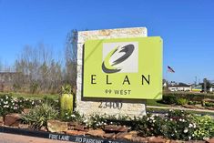 the entrance sign to elan 999 west in front of flowers and trees on a sunny day