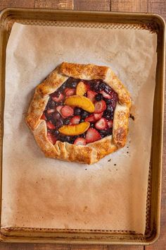 a pie with fruit on it sitting on top of a pan