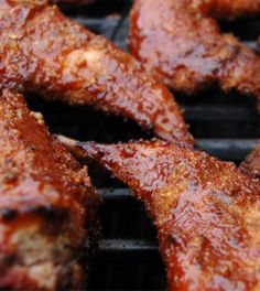 several pieces of meat cooking on a grill