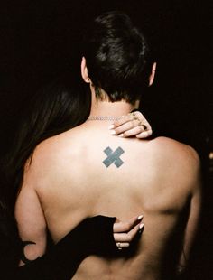 a man with a cross tattoo on his back