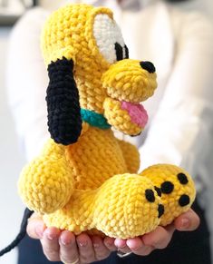 a crocheted stuffed dog is held in someone's hands