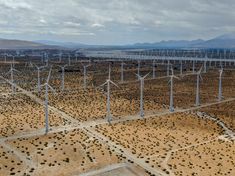 an aerial view of many wind turbines in the desert