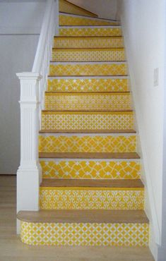 the stairs are painted yellow and white with an intricate pattern on them, as well as a stair rail