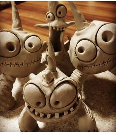 three clay sculptures of cartoon characters are shown