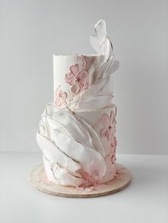 a white and pink cake with flowers on it