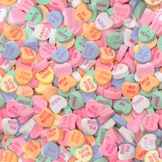 candy hearts with words on them in different colors and shapes are scattered around the image