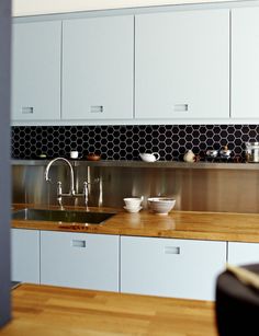 a kitchen with wooden counter tops and white cabinets