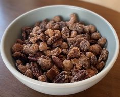 a white bowl filled with nuts on top of a wooden table