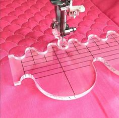 the sewing machine is on top of the pink quilted bed sheet that's stitching