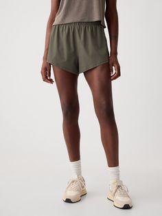 Soft woven athletic shorts.  Elasticized waist.  Double-layer dolphin hem.  Inner shorts.  This running short is made with 86% recycled polyester.  Using recycled materials helps to conserve resources and reduce waste.  * Fit: Relaxed.  An easy silhouette throughout.  Hits above the knee.  Models wearing Gap Affordable Sports Shorts, How To Style Athletic Shorts, Greenish Grey, Womens Athletic Shorts, Workout Fits, Running Short, Gap Fit, Reduce Waste, Athletic Fashion