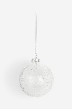 a white ornament hanging from a silver chain