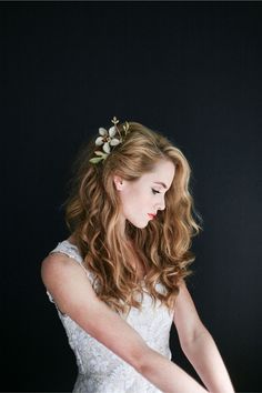 a woman wearing a white dress and holding a knife in her hand with flowers on it