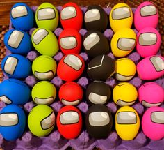 there are many different colored balls on the table together, and one is in an egg carton