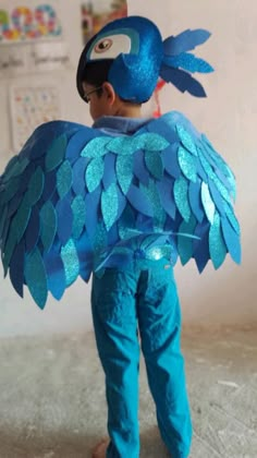 a young boy wearing a blue bird costume