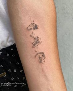 a person with a small tattoo on their arm that has mountains and stars above them