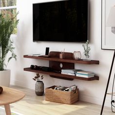 a flat screen tv mounted to the side of a wall next to a wooden table