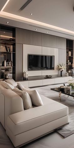 a living room with couches, tables and a television on the wall in it