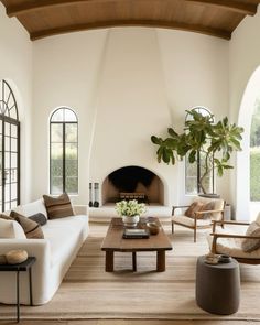 a living room filled with furniture and a fire place in the middle of a room