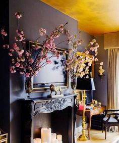 a living room filled with lots of furniture and flowers on top of a fire place