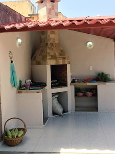 an outdoor kitchen is built into the side of a building with a brick oven and grill