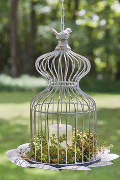 a birdcage filled with flowers and a candle