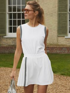 a woman in white dress holding a handbag