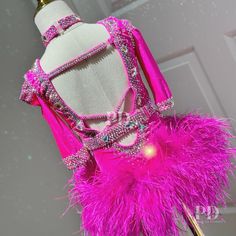 a mannequin is adorned with pink feathers and beads