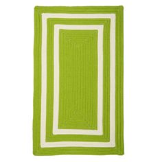 a green and white rug on a white floor with an area rug in the middle