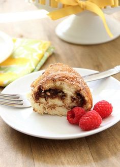 a piece of cake on a plate with raspberries