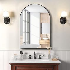 a bathroom with a sink, mirror and lights on the wall next to each other