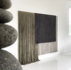 two black and white curtains hanging on the side of a wall next to some rocks