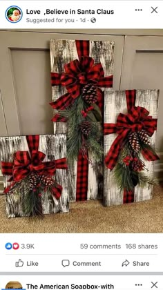 three wooden blocks decorated with pine cones and red bows, sitting on the floor next to each other