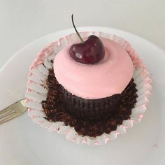 there is a cupcake with a cherry on top and frosting in the middle