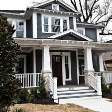 a blue house with white trim and pillars on the front porch is seen in this image