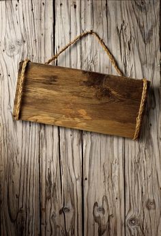 a wooden sign hanging from a rope on a wall